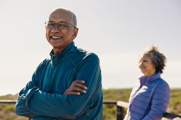 Wall Mural - Happy senior man smiling at the camera while standing on a foot bridge