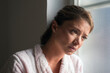 © Solid photos - Young woman in bathrobe suffering from cancer standing beside hospital window