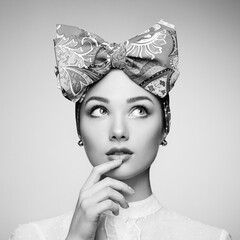 Wall Mural - Portrait of beautiful young woman with bow. Brunette girl. Beauty fashion. Cosmetic make-up. Black and white