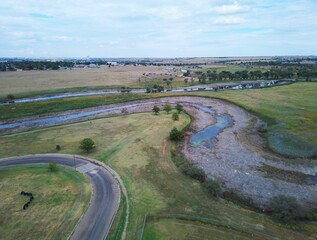 Landscape of Tierra Blanca Creek from north side with green lands and countryside houses in distance