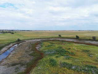 Landscape of Tierra Blanca Creek from south side with green lands and countryside houses in distance