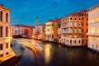 View of Venice's Grand Canal at sunset with illuminated historic buildings and light trails of tourist boats