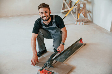 Tile cutting process. The man is making repairs in the apartment