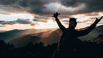 Person with a drone and FPV goggles looking at a spectacular sunset.