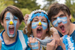 Familia con la cara pintada con los colores de la bandera Argentina alentando al seleccionado en el mundial de futbol. 