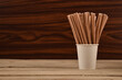 Paper Straws in a Paper Cup on Wooden Table