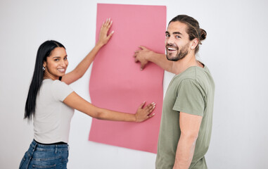 Couple, wallpaper and home, design or renovation with pink poster. Smile, diversity and happy man and woman with banner or paper sheet for decoration, remodeling or renovating in house together