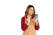 © Phushutter - Coffee shop SME owner excited brunette asian woman wearing sweater and apron isolated on white background, Using mobile