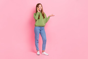 Poster - Full length photo of shiny dreamy schoolgirl wear green sweatshirt communicating modern gadget empty space isolated pink color background