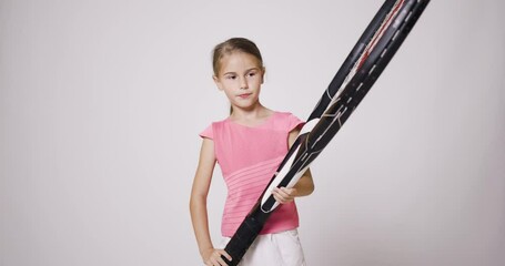 Wall Mural - Young female tennis player with big oversize racket. Girl posing in pink sports outfit and smiling.