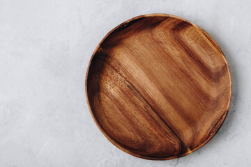 Wall Mural - Wooden plate. Empty wooden plate, plate on gray stone concrete background, top view.