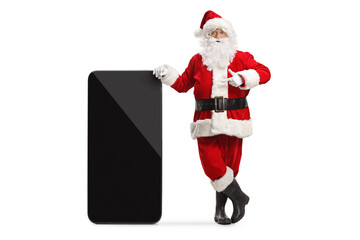 Poster - Santa claus leaning on a big mobile phone and pointing