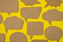 Wooden Empty Speech Bubbles Concept On Yellow Paper Background With Drop Shadow. Copy Space.