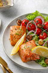 Wall Mural - Baked  Salmon steak with fresh green salad with vegetables, tomatoes, onion. Keto diet concept healthy food, close up.