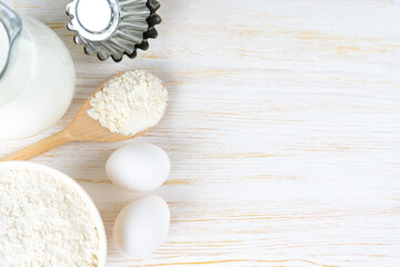 Baking cooking Ingredients background with copy space. Flour, eggs, milk, bakeware on white wooden surface. Top view, flat lay. Mockup menu, banner, header for site, baking concept