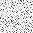 Hand drawn different sized chaotic speckles, flecks, stains or dots seamless pattern. Unusual polka dot black on white abstract monochrome background. Uneven specks, spots, blobs, splashes texture.