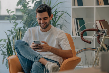 young man at home on sofa with mobile phone