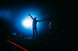 © GALLKS - Popular singer on stage in front of crowd on scene in night club. Bright stage lighting.  Silhouette of a dancing person.