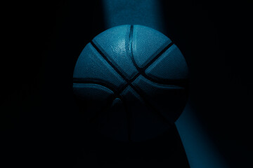 Wall Mural - Basketball ball with natural lighting on blue background. Blue color filter. Sport team concept. Horizontal sport theme poster, greeting cards, headers, website and app