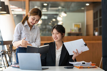 Asian businesswoman working and using laptop Document graph showing the results in the meeting room.