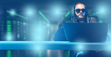 Poster - Hacker man. Computer hacking specialist. Guy with laptop is sitting at table. Hacker in server room. Concept of hacking servers with data. Man internet criminal. Hacker at work. Art blurred