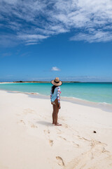 Wall Mural - Cayo de Agua (Los Roques Archipelago), Venezuela, 07.30.2022: a young woman in the white beach with crystalline water.