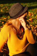 Portrait Of Candid Young Caucasian Blonde Woman In Colorful Autumn Park. Bright Stylish Woman In Yellow Pullover, Black Hat And Shawl Of Neck On Fall Background. Happy Fall Dreaming Concept