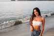 © Hector Pertuz - Portrait of a beautiful diverse latina woman smiling on the beach. Hispanic lifestyle concept.