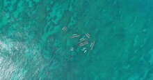 Aerial Top Shot Of Tourists In Hawaiian Outrigger Canoe On Turquoise Sea, Drone Flying Upwards During Sunny Day - Oahu, Hawaii