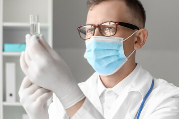 Wall Mural - Male doctor in medical mask with syringe at hospital, closeup