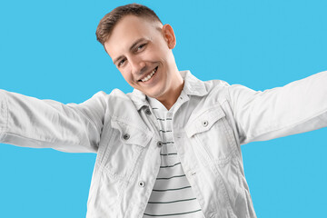 Sticker - Young man taking selfie on blue background, closeup