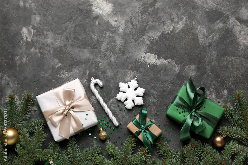 Composition with fir branches, Christmas gifts and decorations on dark background