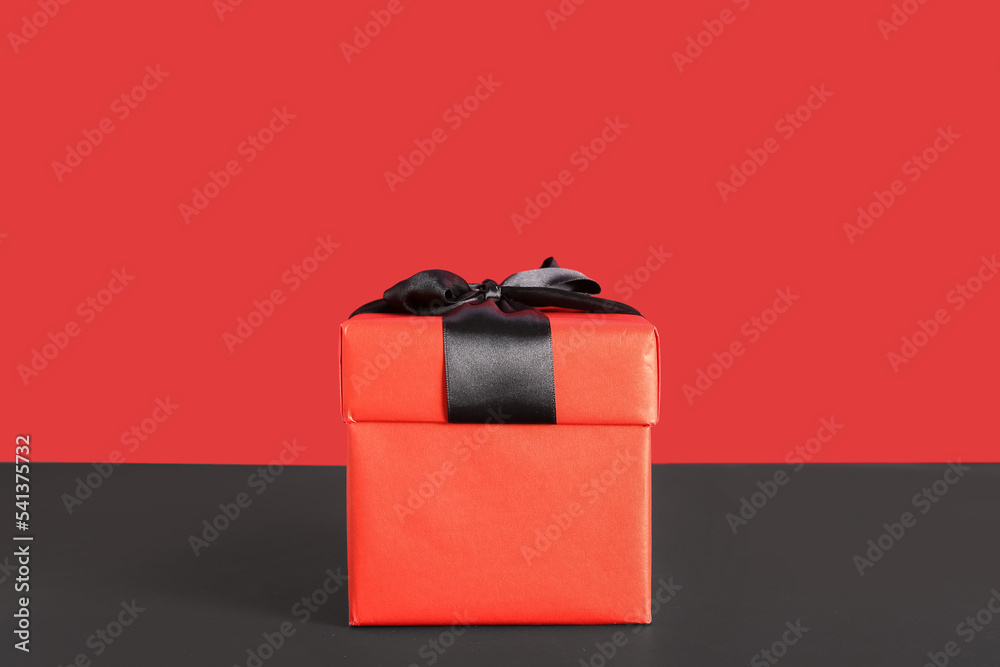 Gift box on color background. Black Friday sale
