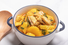 Chicken And Potato Curry With Basil Leaves In A Thai White Bowl