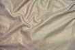 The material is brocade with glitter. Crumpled material with folds. Texture for design.