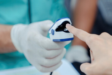  Doctor checking oxygenation with fingertip pulse oximeter. Saturation blood of oxygen. Measuring the patient's blood saturation with an oximeter