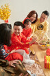 © DragonImages - Boy Eating Treats at Tet Celebration