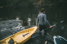 Man Pass The Kayak Across River Rapids