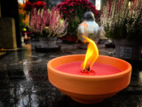 Fototapeta  - ceramiczny znicz płonący na nagrobku