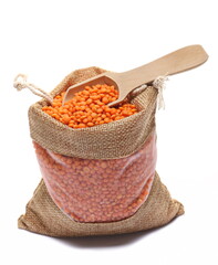 Wall Mural - Pile red lentils in jute linen bag with wooden spoon isolated on white 