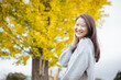 © 望菜 竹内 - イチョウの木の前で笑顔でいる女性  ginkgo woman