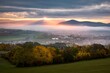 Foggy fall morning near Banska Bystrica. Landscape with forests and mountains around the city. Autumn colored trees at sunrise.