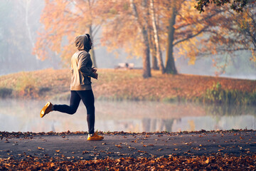 Wall Mural - man jogs in park on autumn morning