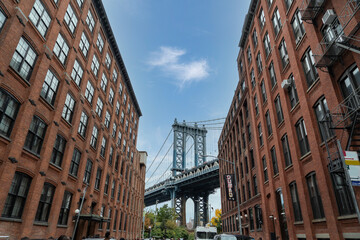 Manhattan Bridge between Manhattan and Brooklyn over East River seen from a narrow alley enclosed by two brick buildings in in Dumbo, Brooklyn, new york city