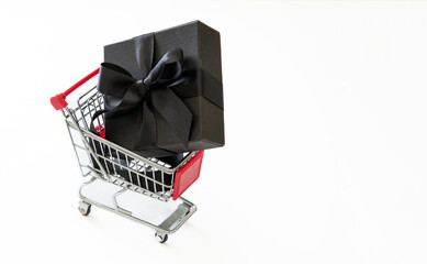 Wall Mural - Black Friday Sale, Christmas Gift box in a Shopping Cart isolated on white