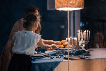 Wall Mural - Food for Hanukkah celebration: Menorah Candles on wooden table, sufganiyot cake and table setting, jewish symbol centerpieces, white and blue. holiday Israel hebrew traditional family celebration