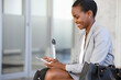 © Rido - Smiling african businesswoman at airport using phone