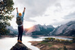 © ADDICTIVE STOCK - Traveler standing on rocky formation near lake