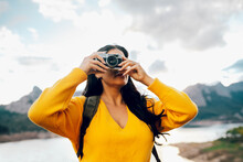 Woman Taking Picture On Camera While Traveling In Nature
