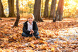 five year old boy posing over autumn background in forest